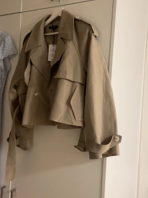 short belted trench coat - Super fin, helt oanvänd, köpt för 799:95 på Gina. Prislappen finns kvar 