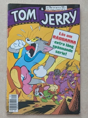 Tom & Jerry serietidning 1991 nr 9 - Serietidning med Tom & Jerry från 1991, nummer 9. Färgstarkt omslag med Tom och Jerry som springer från monster i en grotta. Omslaget är lila, gult och orange med tecknade figurer och text om en extra lång spännande serie om Räddarna. På backsidan längst upp till höger syns märken efter att jag har tagit bort klistermärket med adressen ( syns på bild)
