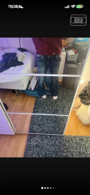 Bootcut jeans rock revival - Säljer ett par blå bootcut jeans med slitningar och broderade detaljer på bakfickorna. Jeansen har vita kontrastsömmar och en avslappnad passform. Perfekta för dig som gillar en casual och trendig stil. Pris går att diskutera❣️