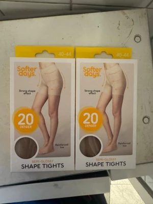 Softer Days shape tights 20 denier - Säljer två par semi-glansiga shape tights från Softer Days i 20 denier. De har förstärkt tå och ger en stark shaping-effekt. Färgen är beige och de är perfekta för att skapa en slät siluett under kläderna.