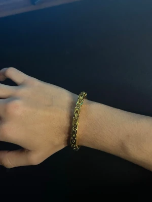 Guldigt länkarmband i metall - Snyggt guld armband som är 4-6mm tjock och är 20cm lång 