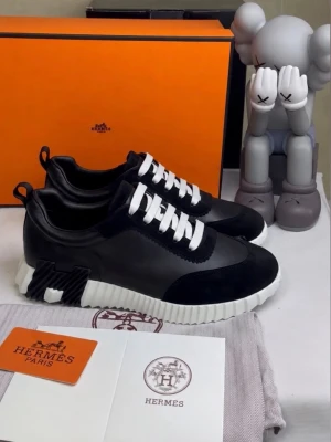 Svarta sneakers med vita detaljer - Snygga svarta sneakers  med vita sulor och vita skosnören. Skorna har en modern design med blandning av läder och mocka samt unika detaljer på hälen. Perfekta för dig som vill ha något exklusivt och trendigt.