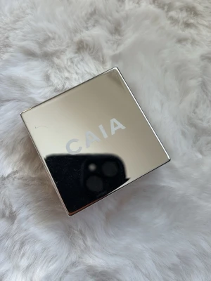 CAIA Wake Me Up Powder Banana - Säljer ett CAIA Wake Me Up Powder i nyansen Banana. Kommer i en snygg, fyrkantig förpackning med spegelblankt lock. Pudret har en ljusgul ton och är perfekt för att ljusa upp och fixera makeupen. Passar dig som vill ha en fräsch och matt finish. Använd fåtal gånger.
