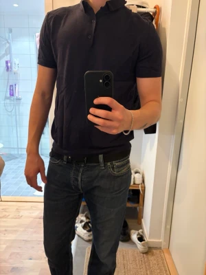 Mörkblå kortärmad skjorta - Säljer en stilren mörkblå skjorta med korta ärmar och klassisk krage. Skjortan har knappar framtill och en enkel, clean look som passar till jeans eller chinos. Perfekt för dig som gillar en avslappnad men ändå snygg stil.