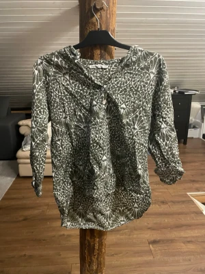 Grönmönstrad blus/skjorta - Snygg blus i grönt och vitt med ett unikt bladmönster. Blusen har trekvartsärm och knappar. Tillverkad i ett lätt och luftigt tyg som känns skönt mot huden. Blusen/skjortan är i storlek XS/S så den passar båda storlekar, men jag själv har S och den passar bra för mej. Perfekt för dig som gillar boho-vibbar och mönstrade plagg.                                                                                            Är öppen för att förhandla priset🌸