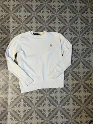 Vit stickad tröja från Polo Ralph Lauren - Skit snygg sweatshirt som är lätt att stila. Perfekt till hösten när de blir lite kyligare 😊🍁. De är en L är lite mindre so kanske skulle passa dom som har M. Inga defekter🤝