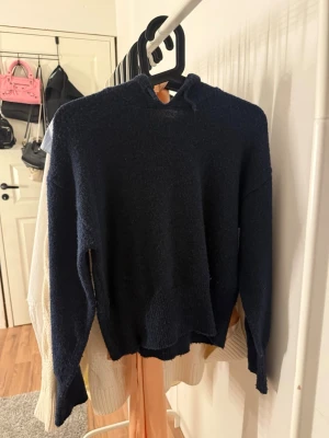Mörkblå stickad hoodie Gina Tricot - Mysig mörkblå stickad hoodie från Gina Tricot med långa ärmar och huva. Enkel och stilren design som passar till det mesta. Storlek 146/152 så passar XS/ liten S. 