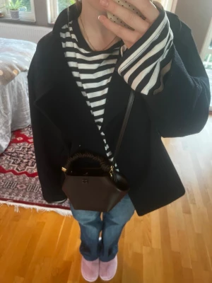 Marinblå oversized ullkappa - Säljer en marinblå oversized kappa med bred krage och avslappnad passform. Kappan är i ullmaterial och har en stilren look som passar perfekt till lager-på-lager. Enkel att matcha med olika outfits för en trendig vibe. Säljer då jag har många jackor