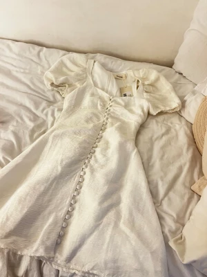 Vit kort puffärmad klänning från Adoore - Säljer den perfekta student & fest klänningen från Adoore. Helt ny med prislapp i storlek 34. Köpte på en sample sale där man ej kunde prova & den passade inte. Ord pris 1495kr 