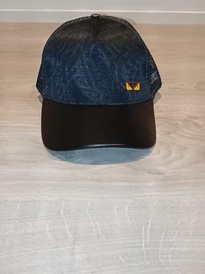 Svart keps från Fendi - Snygg keps från Fendi i svart med mesh på sidorna och bak. Framsidan har en liten gul logodetalj och skärmen är svart. Insidan är dekorerad med Fendi-mönster och logotext. Justerbar baktill för perfekt passform.