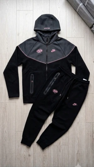 Nytt Nike Tech Fleece "Life of Syn" Limited Edition Set - Storlek L - Säljer ett helt nytt och oanvänt Nike Tech Fleece-set i den exklusiva "Life of Syn"-utgåvan. Dräkten är i nyskick med alla etiketter kvar (10/10). Detta är en unik modell som kombinerar Nikes premiumkomfort med en snygg streetwear-design. Svart bas med kontrasterande rosa sömmar och grafitti-tryck som verkligen sticker ut. Mått (Storlek L): Huvtröja: Längd 62 cm, axelbredd 35 cm. Byxor: Längd 98 cm. Material:(bomull + polyester) Nike Tech Fleece (lätt och värmeisolerande). Skick: Helt ny med tag