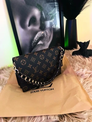 Lyxig och elegant festväska med kedja - Drömmer du om en accessoar som utstrålar lyx och klass? Denna fantastiska vaska ar det ultimata valet för dig som vill glänsa på varje fest och tillstalning. Designen är otroligt elegant och tidlös, vilket gör att den passar perfekt till både finare middagar och exklusiva kvällar ute. Detaljerna med guldfargade inslag ger en lyxig kansla som garanterat drar blickar till sig. Väskan är perfekt skick. Vill du höja din outfit till en ny nivå? Då har du hittat rätt! Hör gärna av dig 