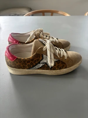 Leopardmönstrade sneakers med glitterstjärna - Jättefina skor från Dune London i storlek 38, på sista bilden ser man att skorna är slitna i ena hälen men är inget som känns när man bär dom