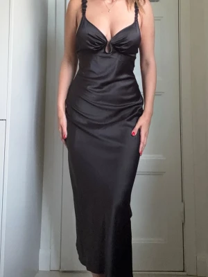 Adoore Svart satin långklänning - Elegant svart satin långklänning och smala axelband. 