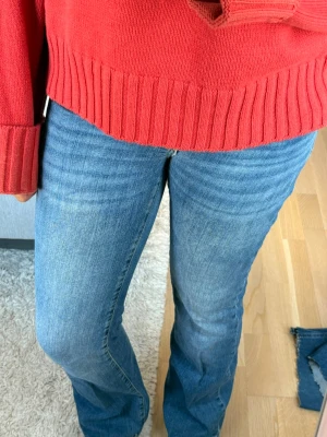 Lågmidjade blå bootcut jeans med stretch - Säljer ett par klassiska blå bootcut jeans med lätt utsvängda ben och snygg tvätt. Jeansen har normal midja och är tillverkade i ett stretchigt denimtyg som sitter bekvämt. Perfekta till en avslappnad och trendig look. Midjemått: 37 inneben:80 längd:105 