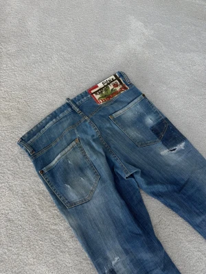 Dsquared2 Jeans - Säljer dessa snygga blåa jeans från D2. Jeansen är i mycket fint skick, finns inga tecken på använing. De är i modellen Cool Guy Jean. Storleken är 48 som motsvarar S,M. 