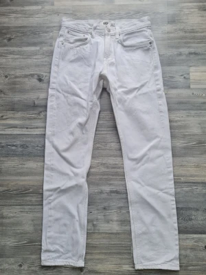 Vita raka jeans - Säljer ett par vita jeans med rak passform och klassisk femficksdesign. Jeansen har normal midja och är tillverkade i ett kraftigare bomullstyg. Perfekta för dig som vill ha en clean och stilren look. Storlek W29 L32
