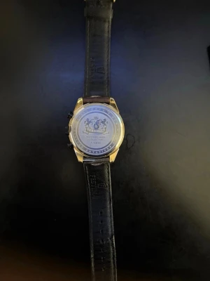 Guldig Festina klocka med svart läderband - Snygg klocka från Festina med guldfärgat boett och svart läderarmband. Urtavlan är ljus med svarta detaljer och flera mindre urtavlor för extra funktioner. Klassisk och stilren design som passar till många olika outfits.