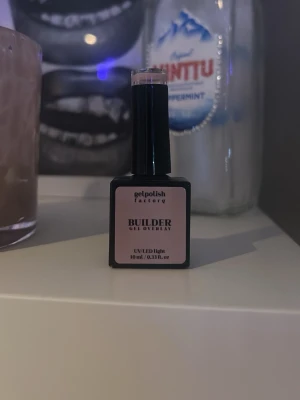 Builder gel overlay nagellack nude - Säljer ett builder gel overlay nagellack i en snygg nude/ljusrosa nyans. Aldrig andvänt köpte till en kompis i födelsedagspresent. Kommer i en fyrkantig flaska med penselapplikator och innehåller 10 ml. Perfekt för att bygga och förstärka naglar med en naturlig look.