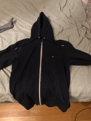 Mörkblå hoodie från Tommy hilfiger - Säljer nu min Tommy hilfiger hoodie då den ej passar, bra skick oxh bra passform och ser oanvänd ut 