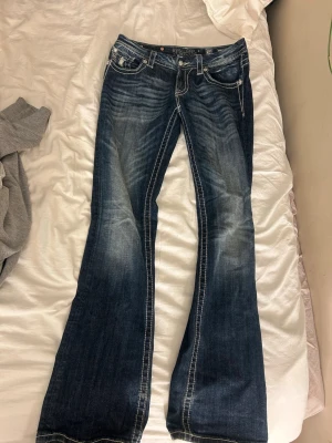 Coola lågmidjade bootcut Miss Me jeans - Ascoola lågmidjade bootcut Miss Me jeans med unika detaljer🤩Sjukt snygga! Står inte storlek men uppskattar ca 36-38 dvs ca strl s-m🙏 Köpta på plick men använda max 2 ggr så i väldigt gott skick! (Öppen för prisförslag)☺️