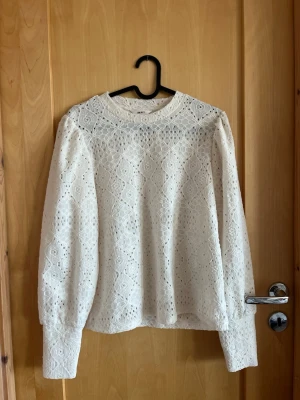 Vit spetsblus från Object/Vila - Säljer en superfin vit spetsblus från Object i storlek XS. Blusen är helt oanvänd. har långärmade puffärmar, rund halsringning och ett detaljerat spetsmönster över hela plagget. Ny pris 400.