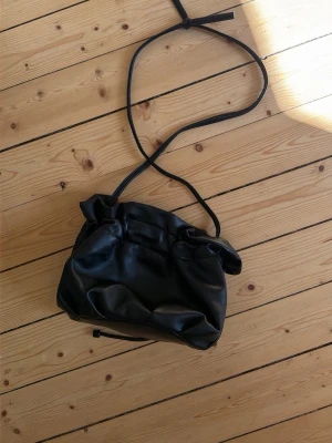Svart axelväska i fejkläder - Bubblig väska från Carin Wester 