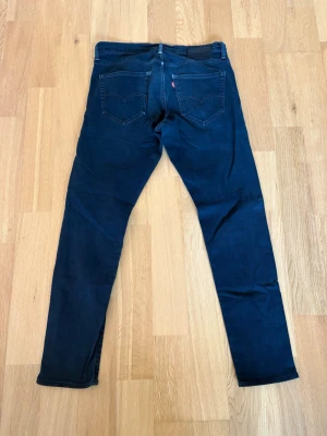Levis jeans  - Ett par Levis jeans med sjukt fin tvätt och till ett riktigt fyndpris! Byxorna är i storlek 31/32 Och har innebens längd på 75cm och midja sida till sida på 41cm. Byxorna är i fint skick utöver hålet som finns i grenen som syns på bild två. Trasig längst sömmen så går o fixa snyggt. Skulle det vara några frågor så skriv annars fritt fram att köpa! (Postar inom 24h)