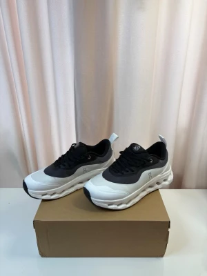 On cloud x Loewe - Snygga sneakers från On cloud x Loewe i svart och vitt med chunky sula och ventilerande meshdetaljer. Skorna har en låg profil, svarta skosnören och logga på sidan. Perfekta för dig som gillar sportig och modern stil.