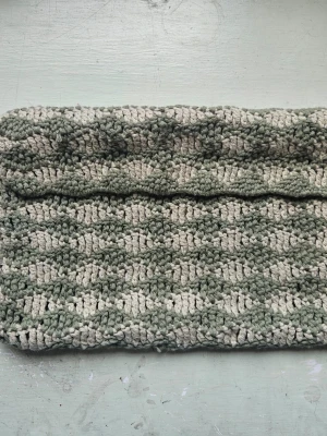 Grön virkad datorväska - virkat datorfodral i två olika gröna nyanser. Bredd 34 cm höjd 20 cm. Passar även till större datorer då den är töjbar. 