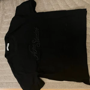  Acne Studios t shirt - Säljer en svart t-shirt från Acne Studios med diskret broderad logga på bröstet. Den har lite speciell passfrom den är lite baggy och inte så lång.