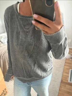 Grå oversized sweatshirt - Mysig grå oversized sweatshirt med rund halsringning och långa ärmar. Tröjan har ett diskret mönster perfekt för en avslappnad look