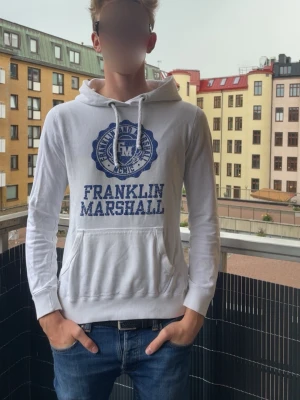 Vintage Hoodie från Franklin & Marshall - Vit hoodie från Franklin & Marshall med blå logga. Perfekt för en avslappnad vintage look. Passar S och M . 