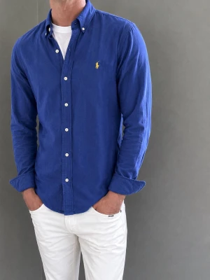 Blå skjorta från Polo Ralph Lauren - Säljer denna Ralph Lauren-skjorta. Modellen är 183 cm lång och väger 76 kg. Skriv gärna för fler bilder eller mått!