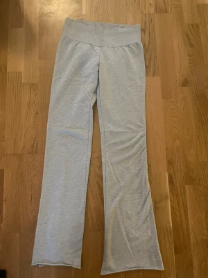 Grå mjuka leggings/byxor med utsvängda ben nelly - Snygga ljusgrå leggings med bred midjeresår och utsvängda ben. Tillverkade i ett stretchigt och mjukt material som sitter bekvämt. Perfekta för en avslappnad och trendig look. Nelly. Det står storlek xxs men de är lite uttöjda så skulle säga xs.