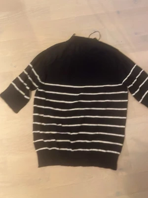 Mörkblå tröja med vita ränder - Säljer en mörkblå tröja med vita horisontella ränder och halvlånga ärmar. Tröjan har en rund halsringning och ribbad nederkant. Perfekt för hösten🍁🤎