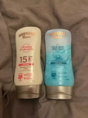 Hawaiian Tropic sol- och after sun lotion - Två flaskor från Hawaiian Tropic: en Glowing Protection SPF 15 solskyddslotion i beige förpackning och en Hydrating After Sun lotion med aloe i blå förpackning. Båda har tropisk doft och praktisk tubform, perfekta för återfuktning och skydd av huden. Halva kvar i båda minst!