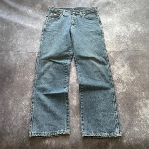 Blå Wrangler-jeans för herr i 2000-talsstil, storlek W30 L32 - Blå Wrangler-jeans för herr med en stil inspirerad av 2000-talet.  Mått 📏 Midja: 39 cm Benslut: 20 cm Lår: 32 cm Totallängd: 103 cm Måtten hittas även på bilderna  Paketet postas inom ett dygn Spara på priset och fraktkostnaderna genom att sätta ihop ett paket Mer info finns på min profil