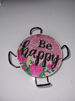 Färgglada glittriga underlägg med citat - Säljer ett set med runda underlägg dekorerade med färgglada strasstenar och inspirerande citat som 'Be happy', 'Follow your heart' och 'You are awesome mm. Underläggen har blommiga motiv i rosa, blått, grönt och gult. Materialet är hård plast med metallställ. Perfekta att använda till kaffe, te eller andra drycker när familj och vänner kommer på besök. De färdiga underläggen blir en fin detalj på bordet och ett roligt sätt att visa upp din kreativitet.  Handgjord med kärlek av mig 🌺 Oanvända. 