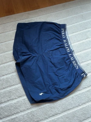 Blåa ralph lauren badshorts  - Blåa raplh lauren badshorts. Storlek Xl men är ganska korta. Fraktar direkt efter köp 