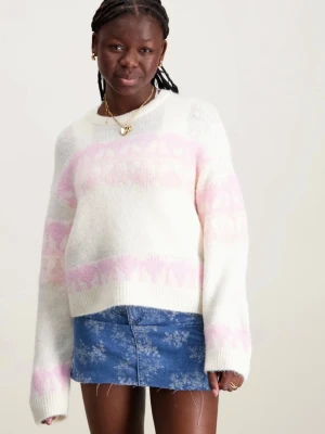 Vit stickad tröja med rosa mönster - Mysig stickad tröja i offwhite med breda rosa mönsterband över bröstet, ärmarna och nederkanten. Tröjan har rund halsringning och ribbstickade muddar. Perfekt för kalla dagar och ger en söt retrovibe.