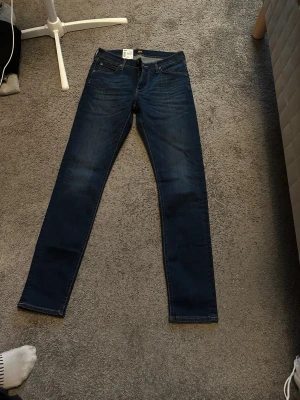Mörkblå Lee jeans NYA! - Säljer ett par mörkblå skinny jeans med klassisk femficksdesign och smal passform. Jeansen har subtila slitningar och kontrastsömmar. Tillverkade i stretchigt denimtyg för extra komfort. Perfekta för dig som gillar en tajt look. Aldrig använda helt nya då dom inte passade