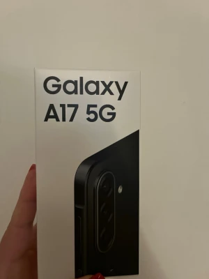 Galaxy A17 5G mobiltelefon svart helt ny  - Säljer en Samsung Galaxy A17 5G i svart. Telefonen har en modern design med rundade hörn och flera kameror på baksidan. Perfekt för dig som vill ha snabb 5G-uppkoppling och snygg stil. Levereras i originalförpackning.