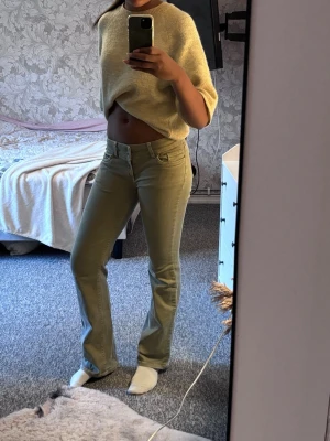 Gröna nelly jeans - Snygga gröna bootcut jeans med broderade detaljer på bakfickorna. Jag är 1,77m lång