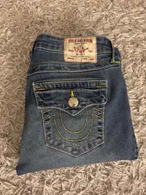 True Religion bootcut jeans blå - Säljer ett par blå bootcut jeans från True Religion med jättefina bakfickor. De är oanvända och är superfina på. Perfekt för dig som vill ha nya snygga jeans. Pris kan diskuteras