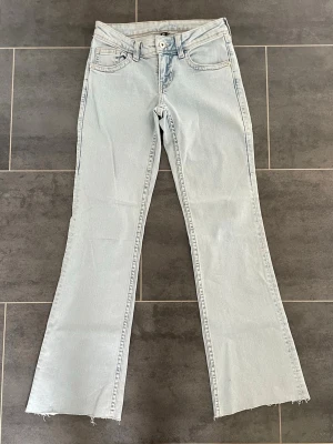 Ljusblå lågmidjade bootcut jeans - Säljer ett par jätte snygga ljusblåa lågmidjade jenas från H&M. De är avklippta längst ner och passar mig som är 155 cm.