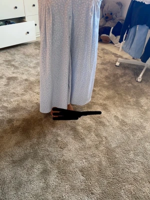 Ljusblå långkjol från Monki XS - Säljer en ljusblå långkjol från Monki i storlek XS. Kjolen har ett blommönster Perfekta för en chill och avslappnad stil.