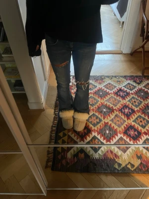 Blå slitna bootcut jeans - Säljer ett par blå bootcut jeans med slitningar och hål från subdued.