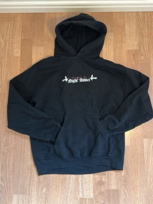 Svart graphic hoodie - Svart hoodie från Night Addict med huva. Tröjan har riktigt feta tryck med många detaljer som gör att tröjan sticker ut. Sitter skönt och passar till det mesta. Tveka inte på att höra av dig vid funderingar!✨