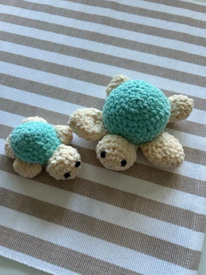 Två virkade sköldpaddor - Säljer två handgjorda virkade sköldpaddor i beige och ljusblå garn. De har runda kroppar, små ben och svarta broderade ögon. Perfekta som dekoration eller leksak. Säljes som par.
